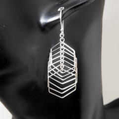 A pair of handcrafted 925 sterling silver drop earrings featuring multiple layered hexagon shapes with a high-polished finish, shown on a black display stand.