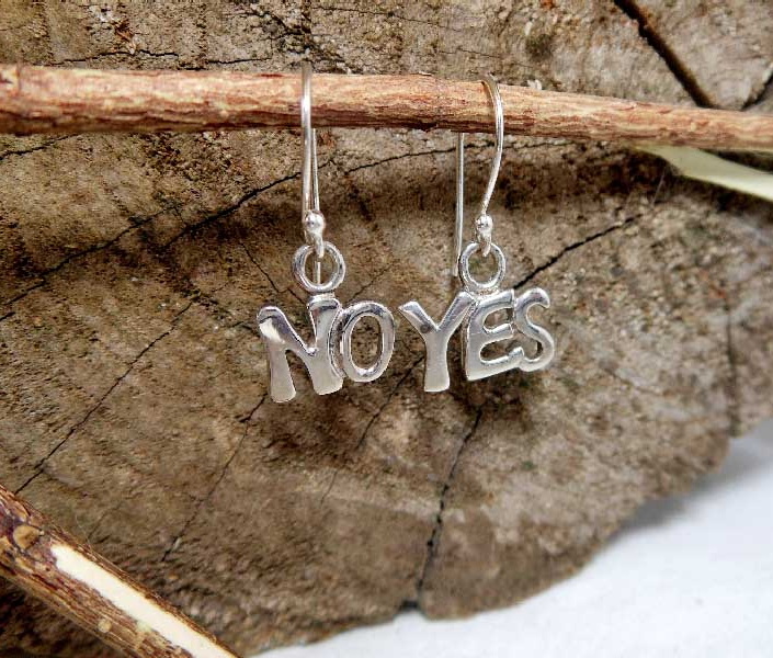 A pair of handcrafted 925 sterling silver mismatch earrings featuring "YES" and "NO" word letter pendants, displayed on a rustic wooden background.