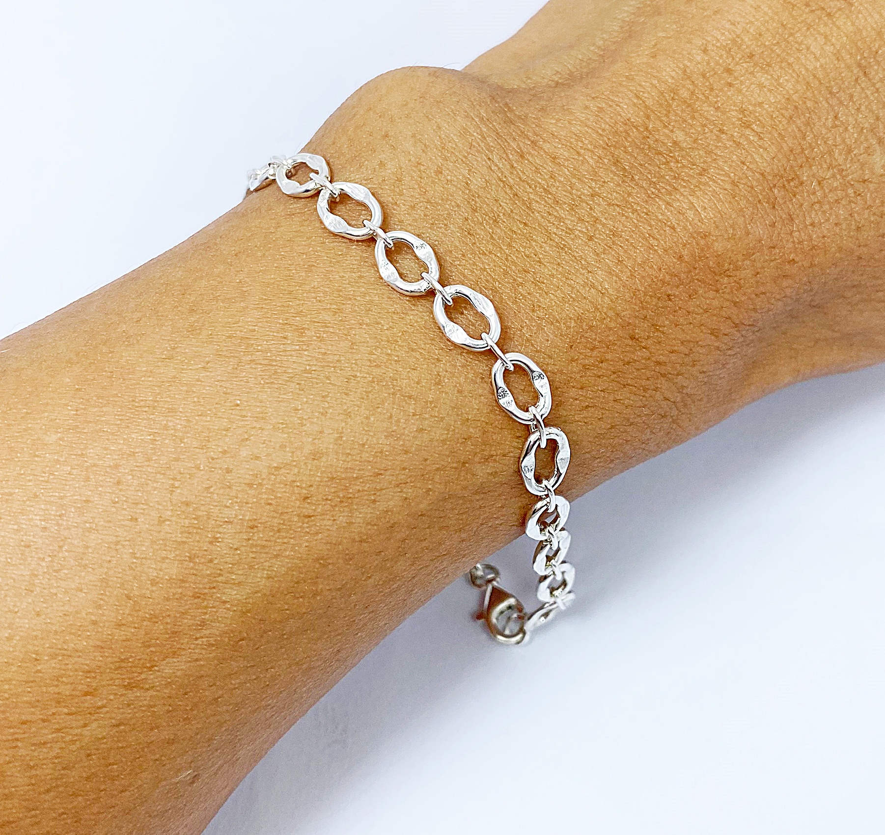 A detailed close-up of a handcrafted 925 sterling silver square box braided chain bracelet, featuring a prominent circular pendant clasp, worn on a wrist.