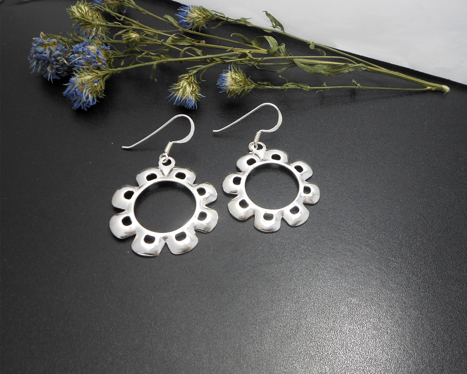 A pair of handcrafted 925 sterling silver flower dangle earrings featuring a high-polished, smooth floral design.
