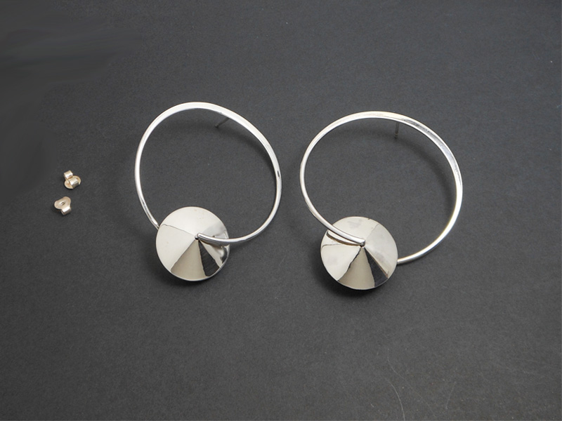 A pair of handcrafted 925 sterling silver drop stud earrings featuring a unique spinning Saturn-inspired planetary design, elegantly displayed on black background.