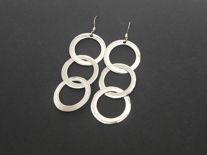A pair of handcrafted 925 sterling silver drop earrings featuring three interconnected smooth, high-polished circles, displayed on a black background.