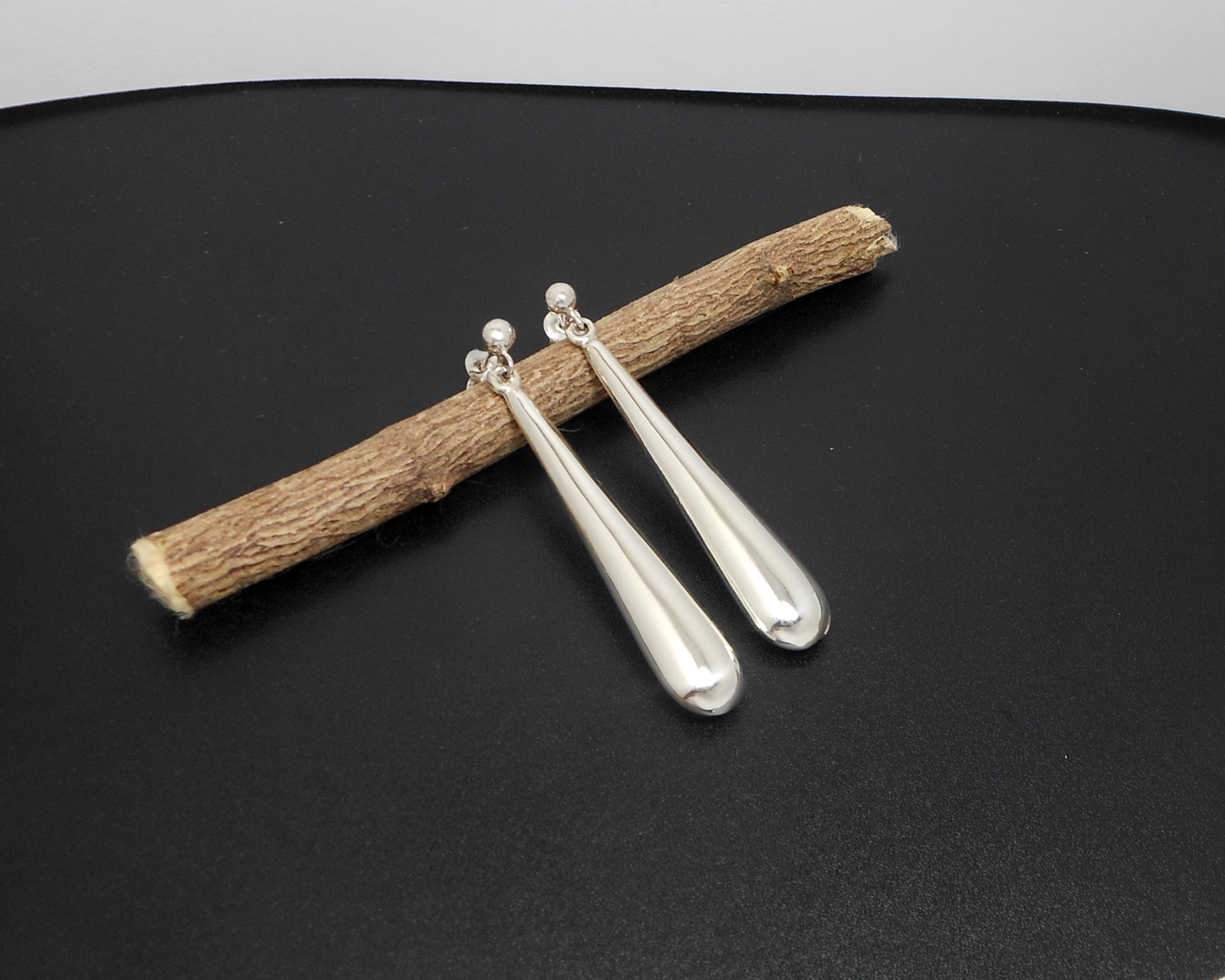 A pair of handcrafted 925 sterling silver puffy long teardrop stud dangle earrings featuring a smooth, high-polished finish.