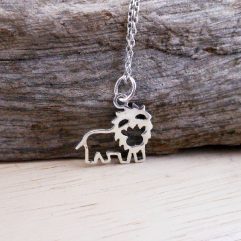 A detailed close-up of a handcrafted 925 sterling silver cutout lion pendant necklace displayed against a natural wood background.