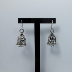A pair of handcrafted 925 sterling silver bell-shaped drop earrings featuring intricate Thai art textured patterns and a high-polished oxidized finish, displayed on a stand.