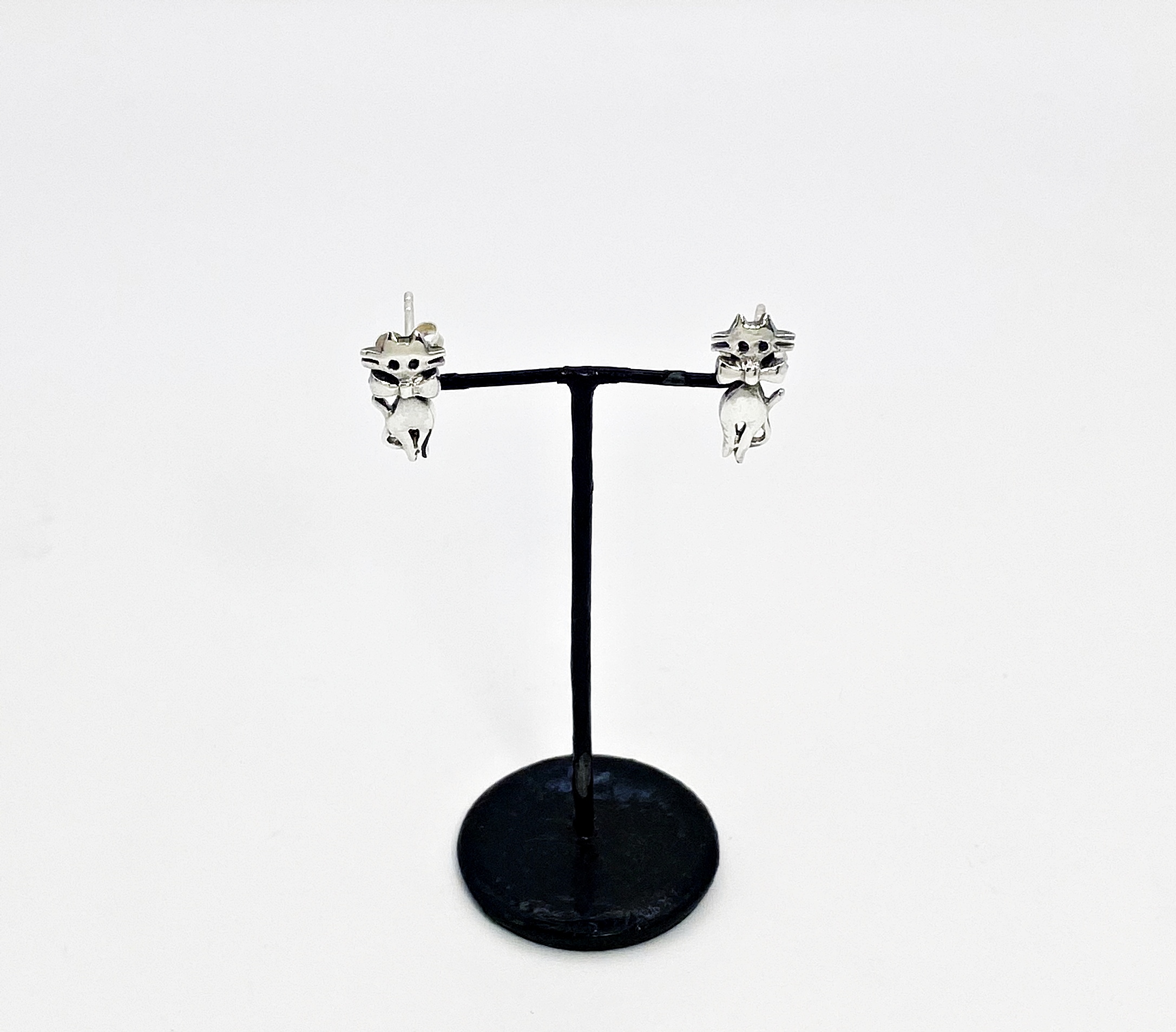 minimalist 925 sterling silver cat stud earrings on display stand.