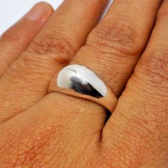 A sleek, handcrafted 925 sterling silver tapered dome ring with a high-polished finish, shown on a hand.