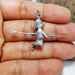A detailed macro photograph showing a handcrafted 925 sterling silver wizard pendant with an articulated movable design held in an open palm.