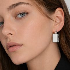A close-up profile view of a model wearing 3D square hoop earrings, meticulously handcrafted from high-polished 925 sterling silver.