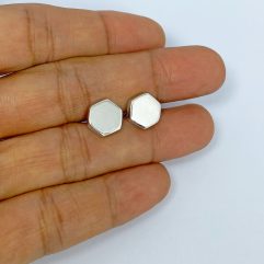 Pair of handmade 925 sterling silver puffy hexagon-shaped stud earrings featuring a smooth, polished finish, shown held in hand