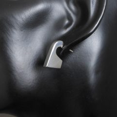 Pair of handmade 925 sterling silver puffy geometric stud earrings with a sleek, architectural design, shown on a mannequin.