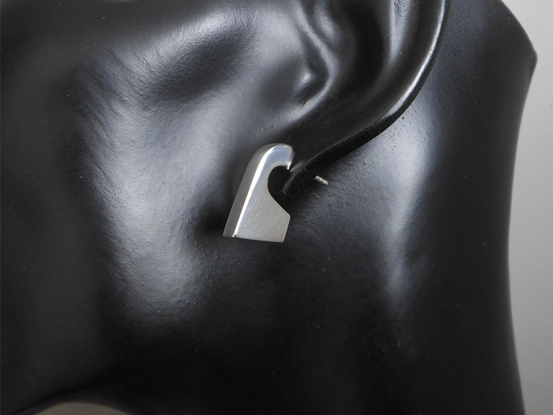 Pair of handmade 925 sterling silver puffy geometric stud earrings with a sleek, architectural design, shown on a mannequin.