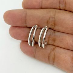 Pair of handmade 925 sterling silver hoop earrings featuring a unique solid, petal-inspired open design held in a palm.