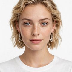 Model wearing the sterling silver cutout giraffe dangle earrings.
