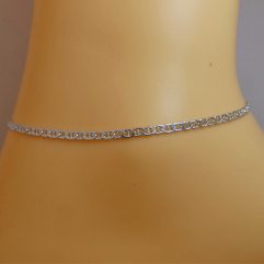 Side profile view of the polished 925 sterling silver anchor Mariner chain anklet on an ankle.