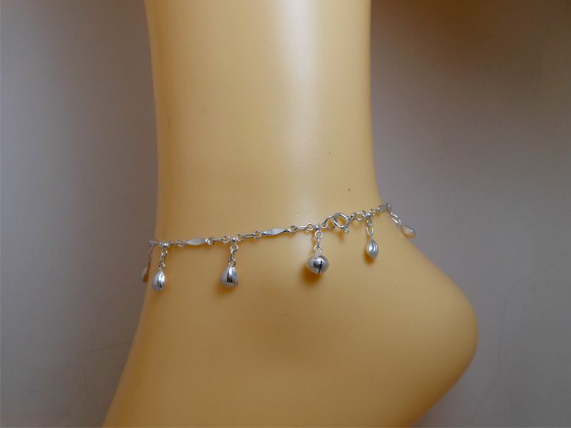 Side profile view of the scallop shell charm anklet on an ankle
