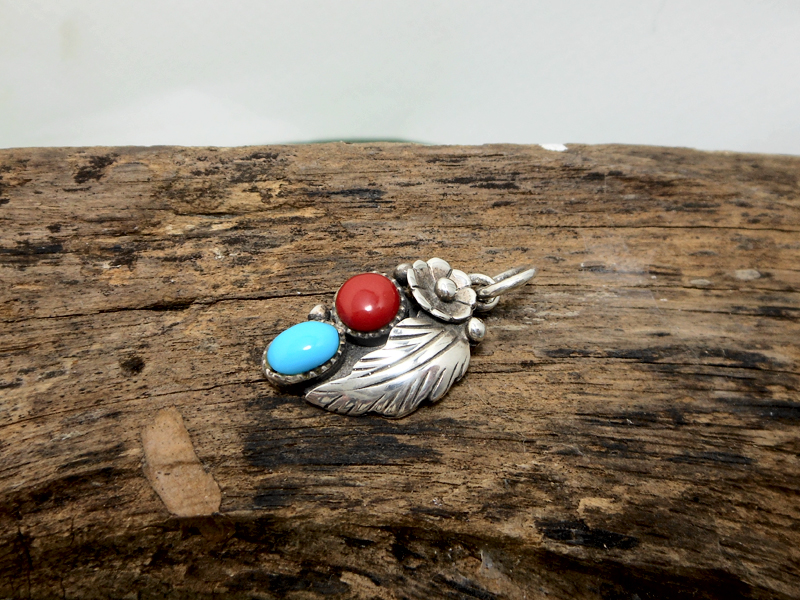 Side view of left-facing turquoise and coral sterling silver pendant