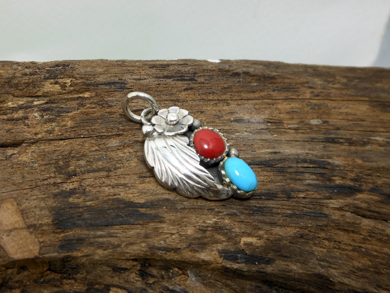 Side view of right-facing turquoise and coral sterling silver pendant