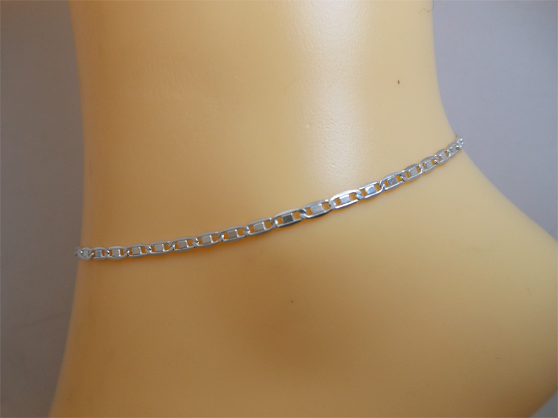 Detailed view of a polished 925 sterling silver Valentino chain anklet worn on an ankle