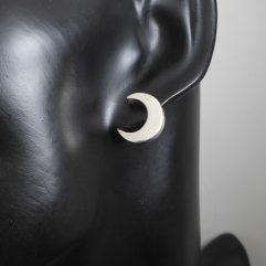 Pair of handmade 925 sterling silver puffy crescent moon stud earrings shown on a mannequin, featuring a smooth, high-polished finish.