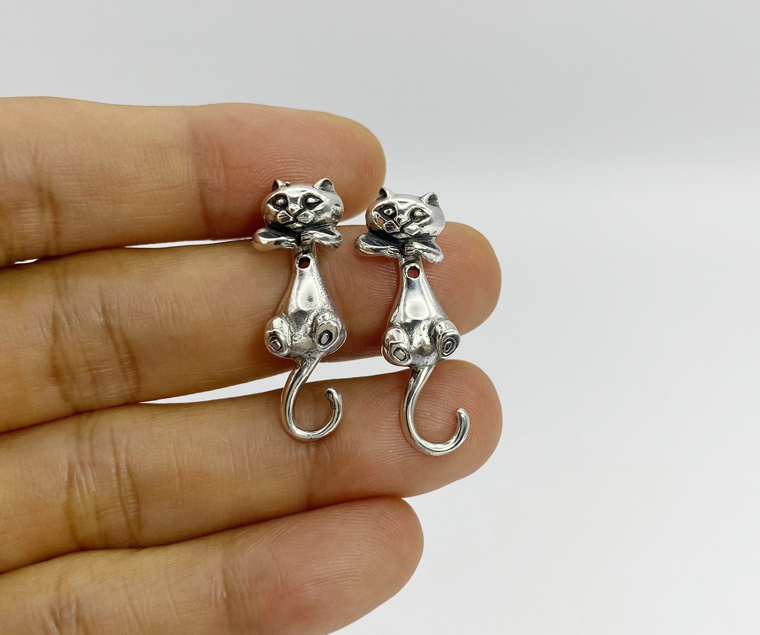 Handheld view of 925 sterling silver cat earring jackets