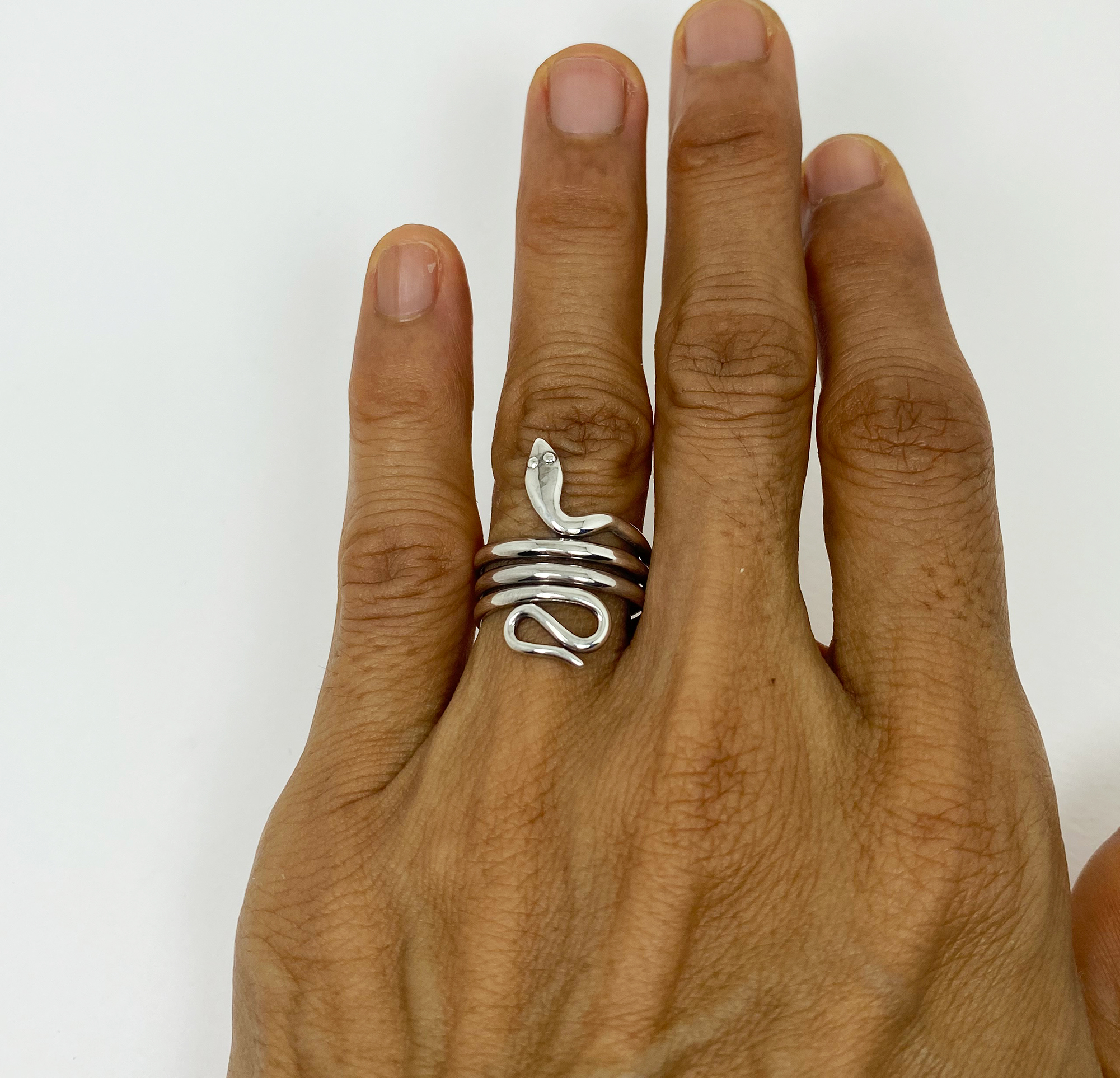 Handcrafted 925 sterling silver ring featuring an elegant coiled snake design, shown worn on a finger.