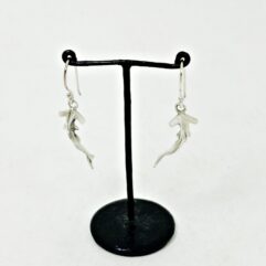 Pair of solid 925 sterling silver hammerhead shark drop earrings with oxidized details on a black jewelry stand by Sup Silver.