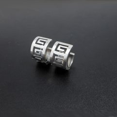 A pair of handcrafted 925 sterling silver Greek Key huggie hoop earrings with a matte finish, displayed on a dark background.