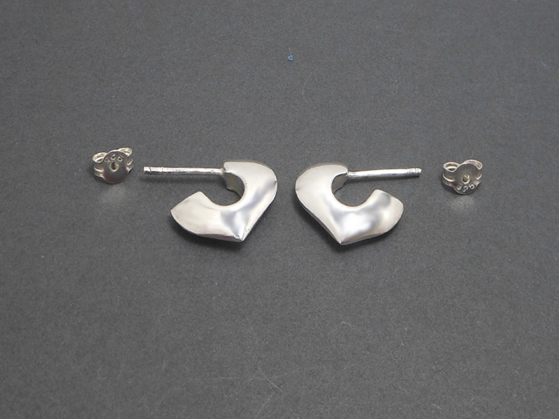 Pair of handmade 925 sterling silver puffy heart-shaped open hoop stud earrings with a high-polished finish, shown on a dark background