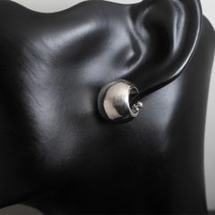 Pair of handmade 925 sterling silver puffy wide hoop earrings shown on a model