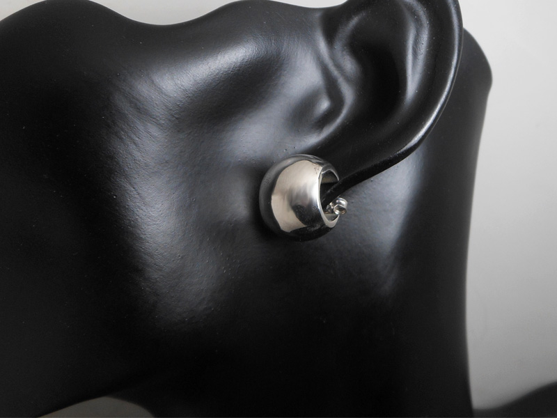 Pair of handmade 925 sterling silver puffy wide hoop earrings shown on a model