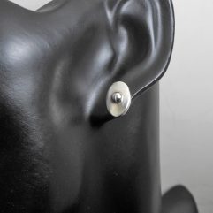 Pair of handmade 925 sterling silver oval stud earrings featuring a raised center bead and a high-polished finish, shown modeled.