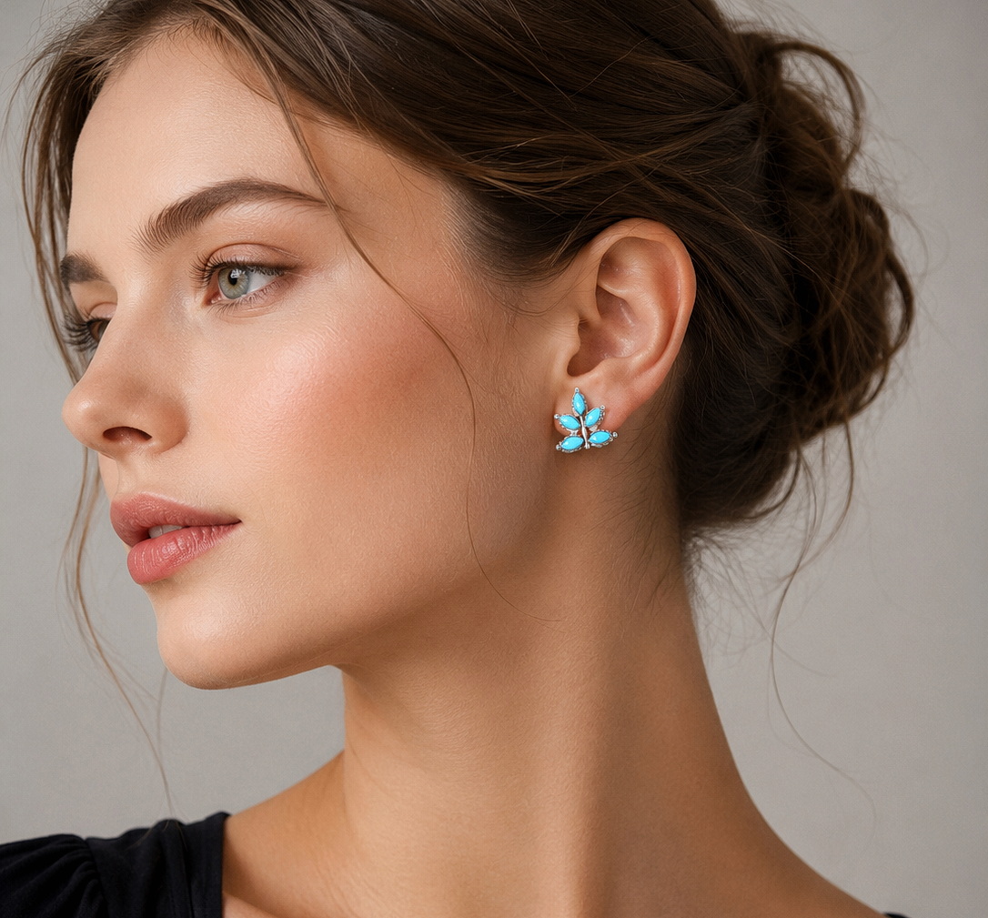 European model wearing turquoise and coral floral dangle earrings (ET78) with a black top on a light gray studio background.