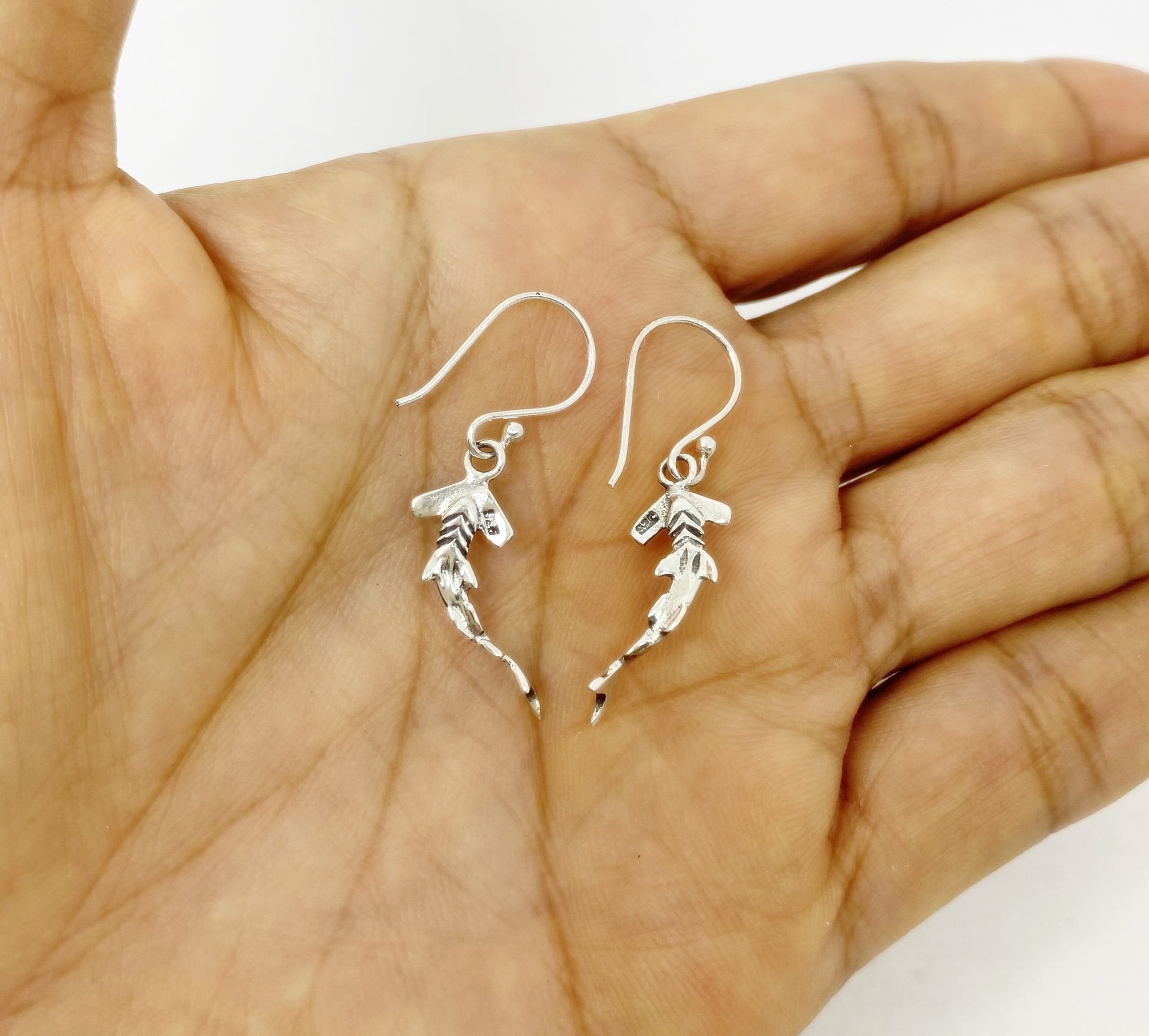 Sterling silver hammerhead shark earrings back view on hand