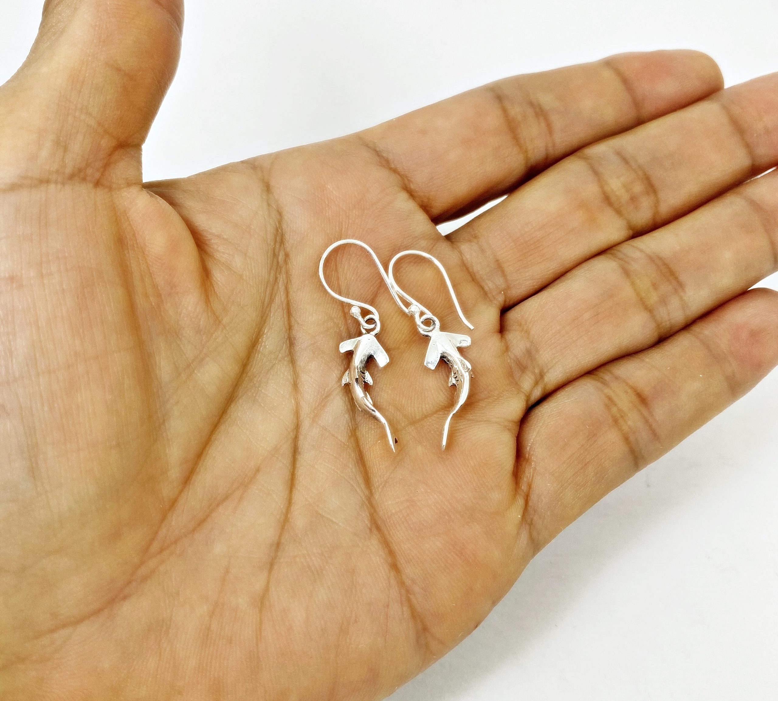 Sterling silver hammerhead shark earrings front view on hand