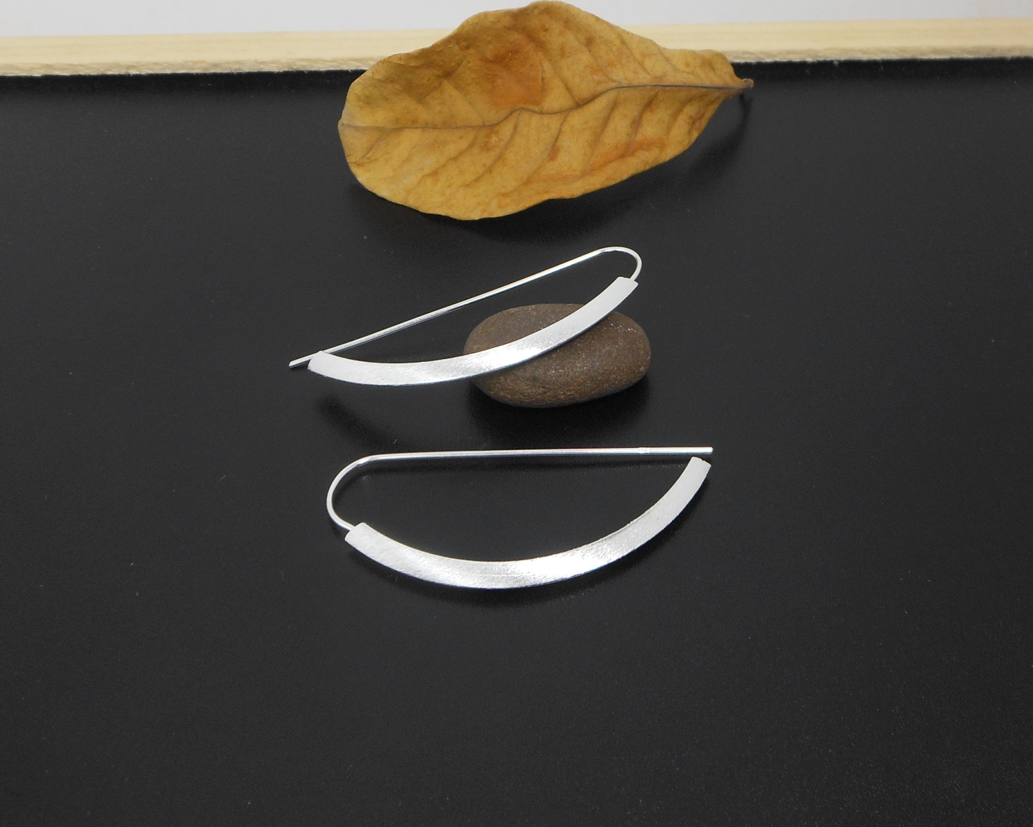 Top-down view of arc D-hoop threader earrings.