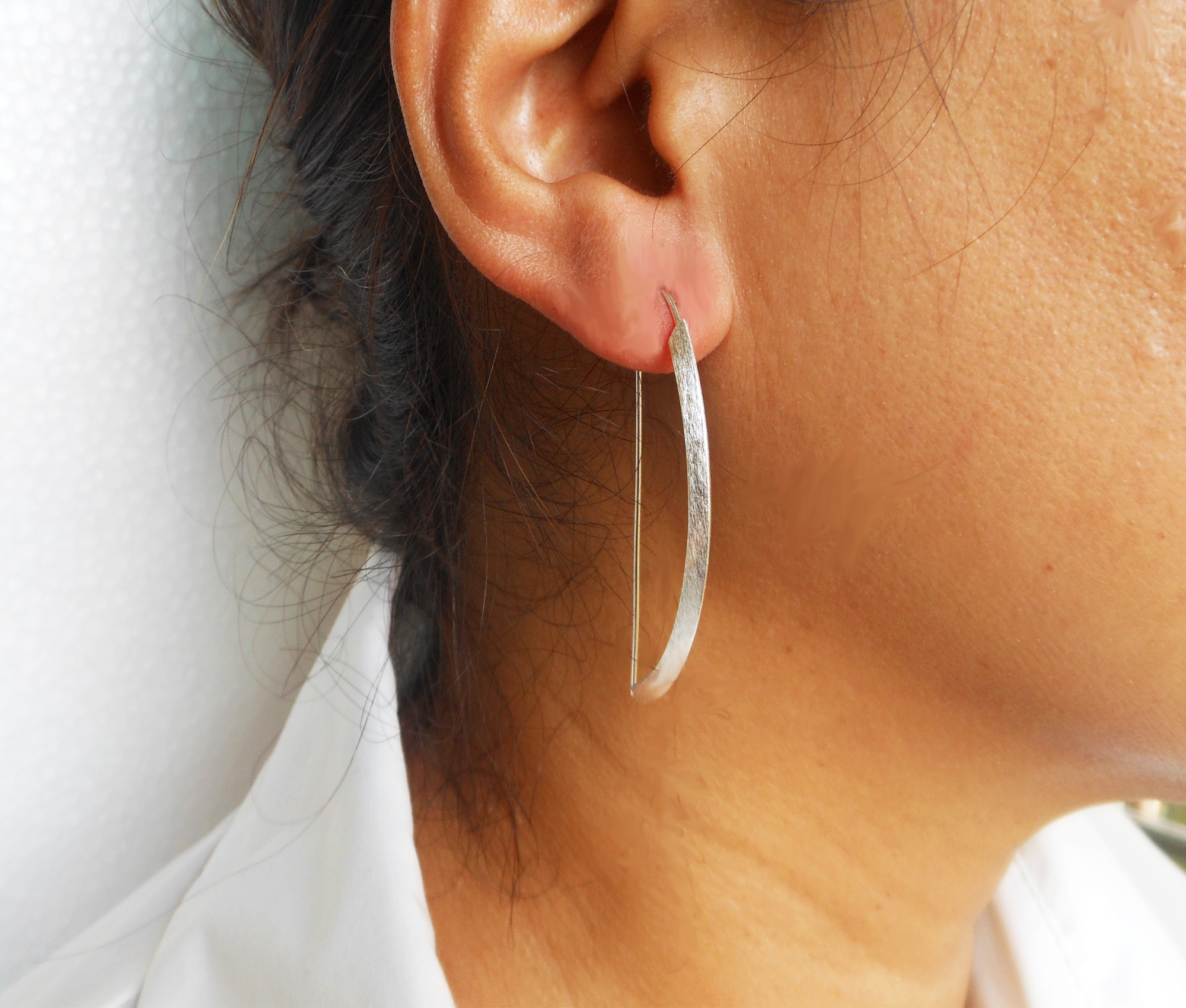 Side profile of a model wearing arc D-hoop threader earrings.