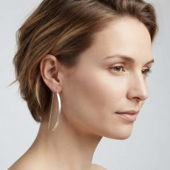 A model wearing handmade sterling silver arc D-hoop threader earrings.