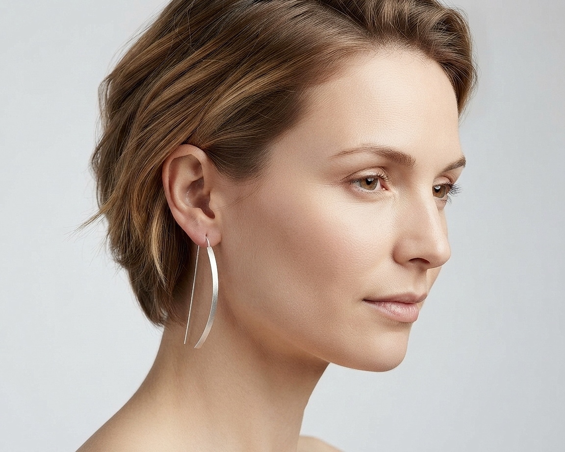 A model wearing handmade sterling silver arc D-hoop threader earrings.