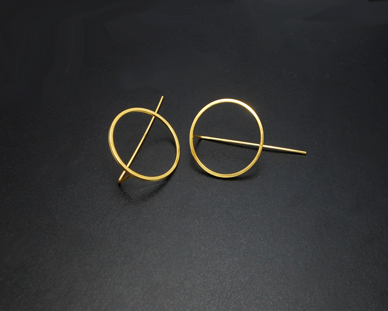 Top-down view of gold circle threader earrings.