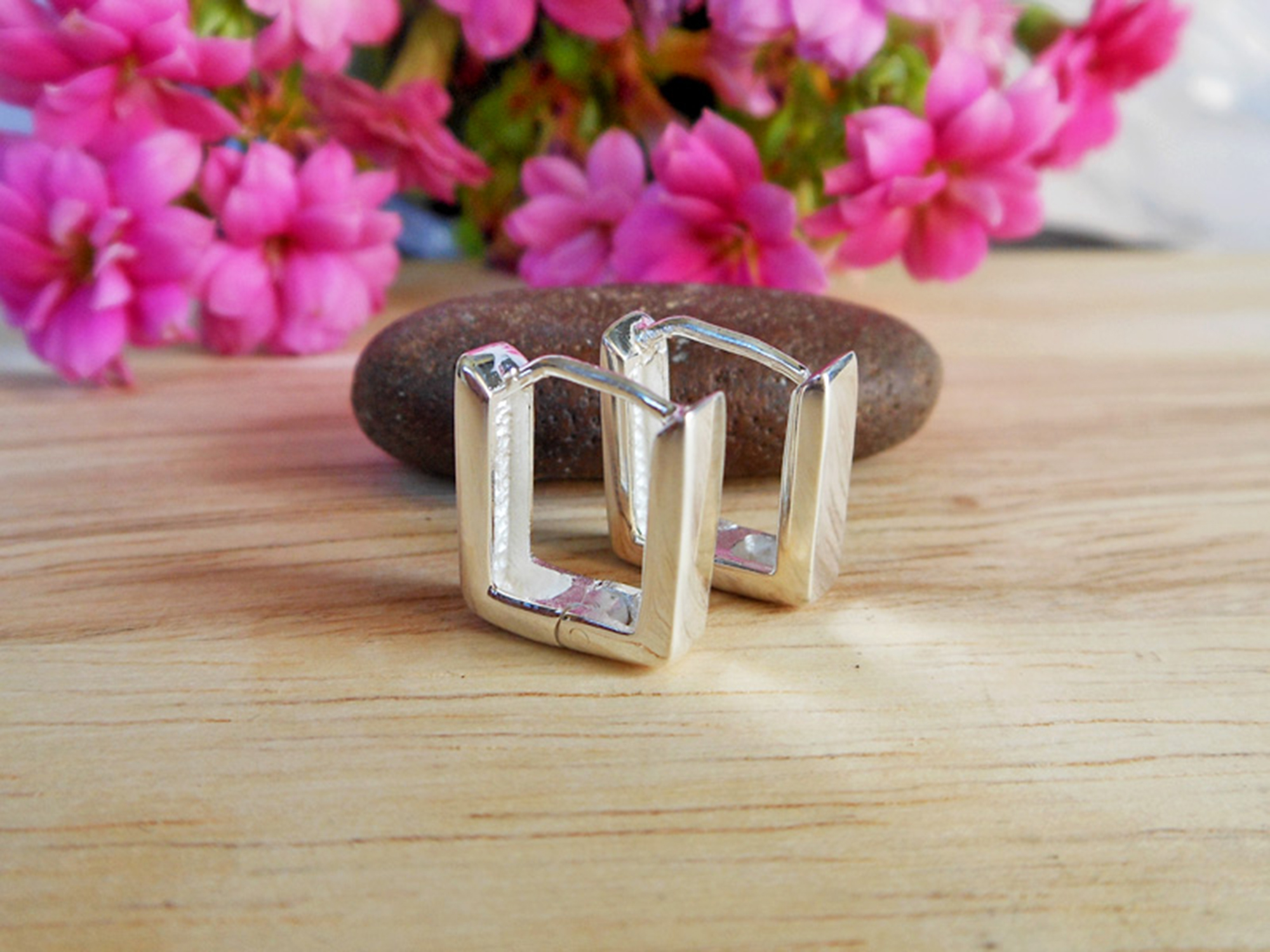 Handmade 925 sterling silver flat square huggie earrings with a floral backdrop.