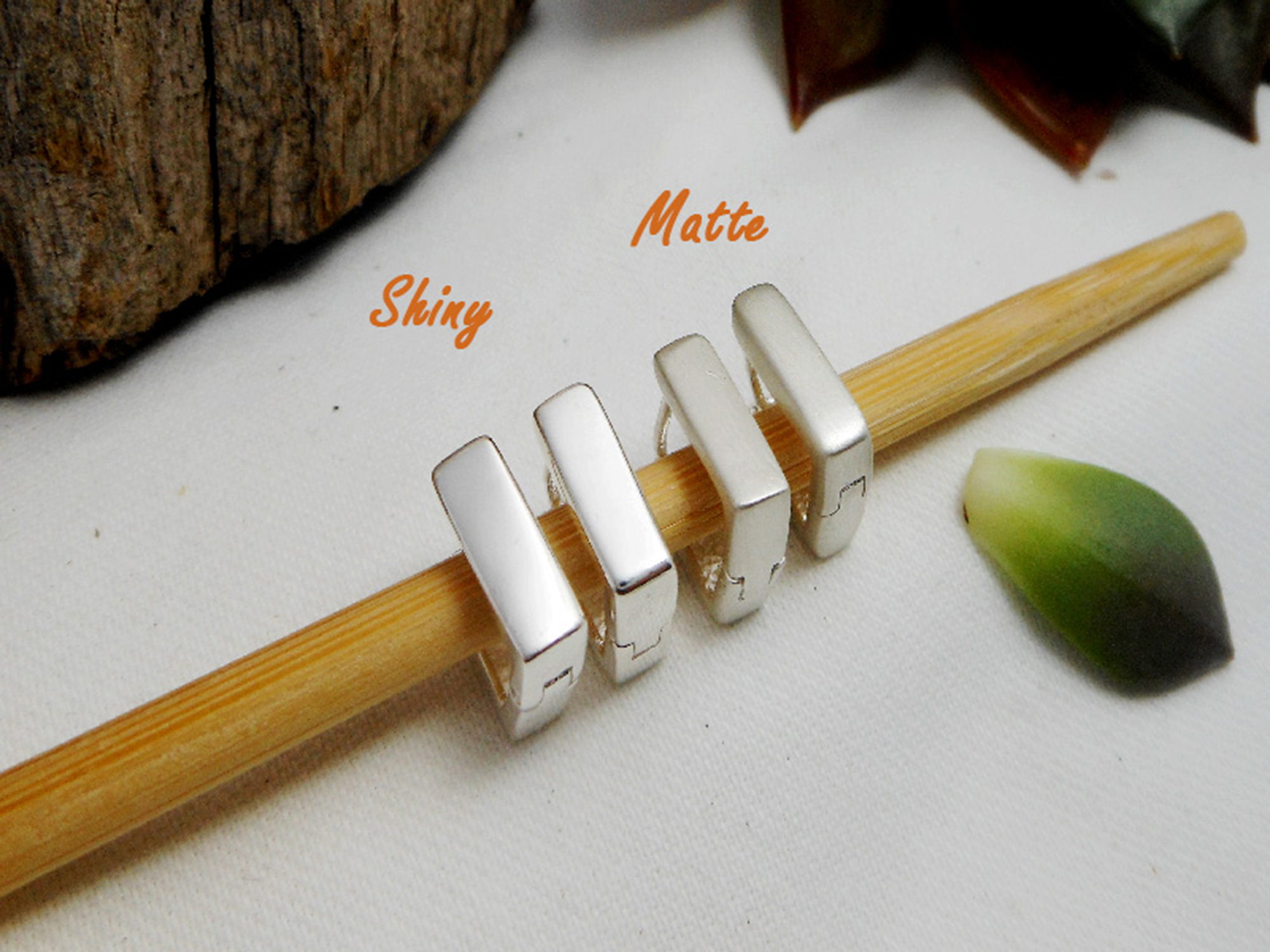 pair of handmade 925 sterling silver flat square huggie earrings displayed on a wooden surface.