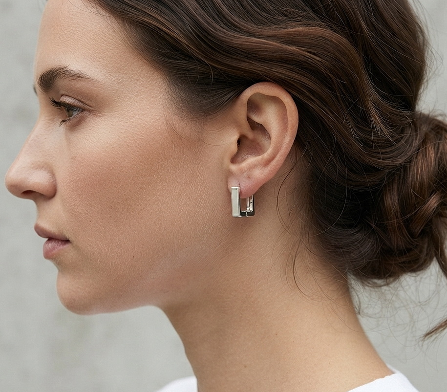 A model wearing handmade 925 sterling silver flat square huggie earrings.