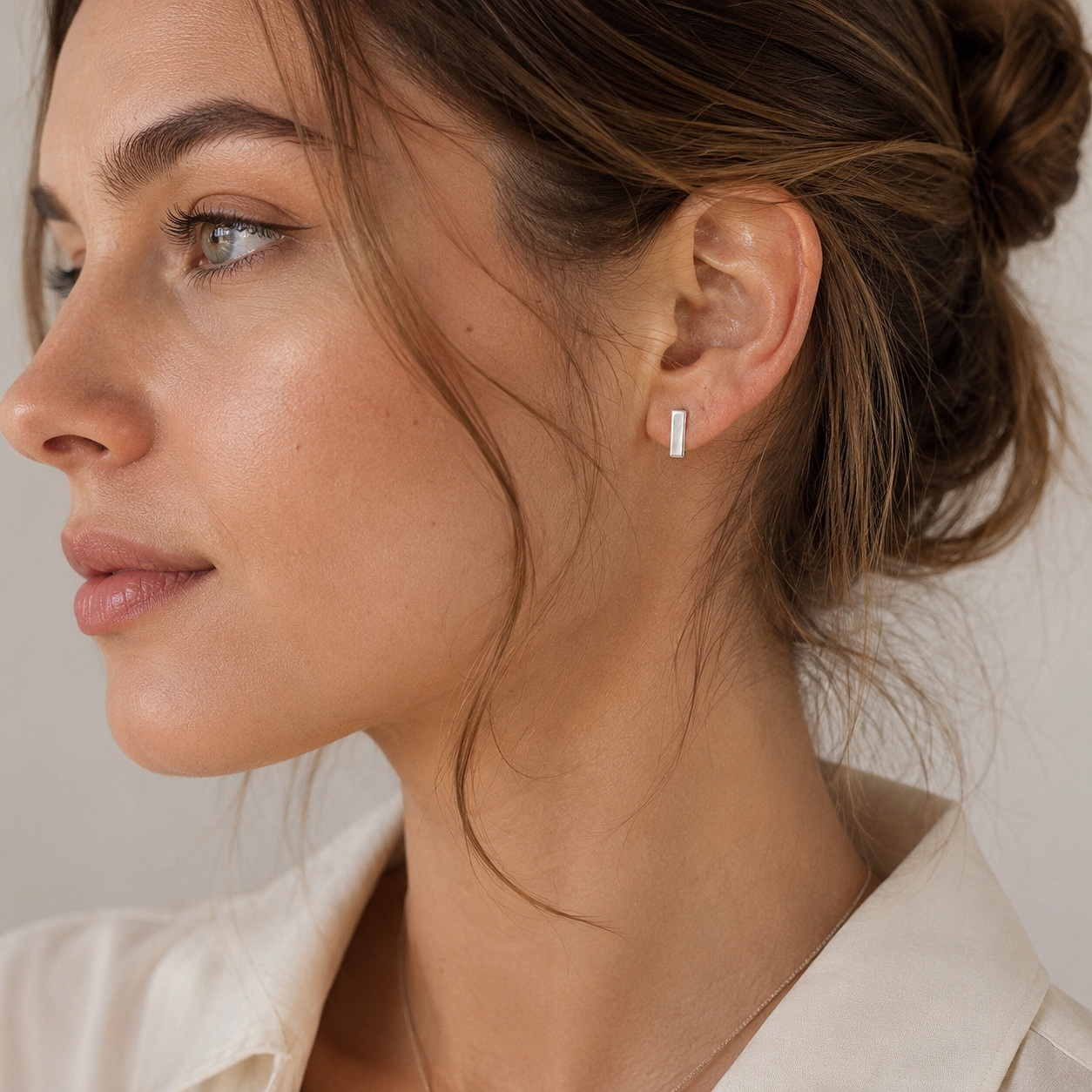 A model wearing handmade 925 sterling silver flat square huggie earrings.