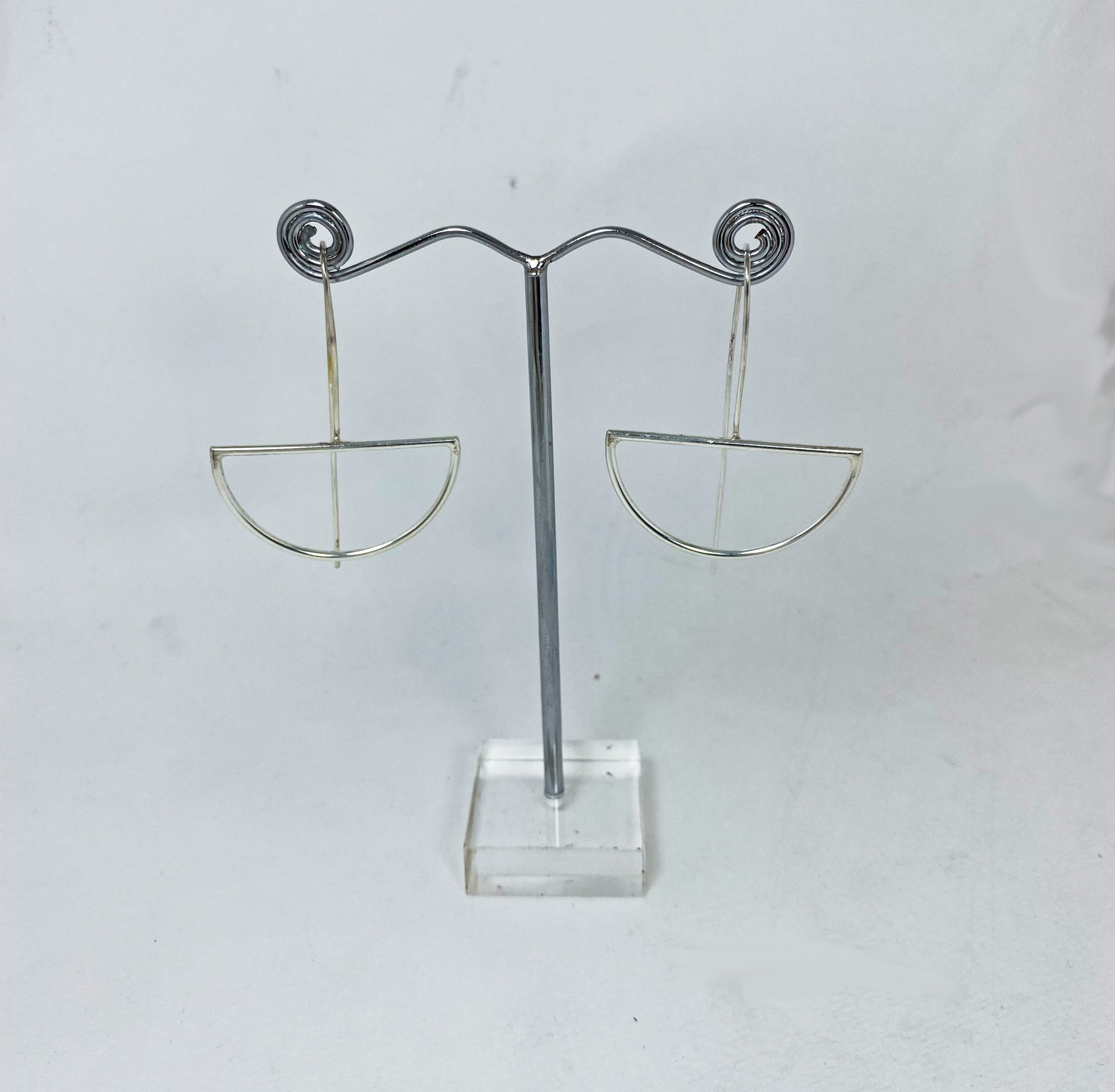 Pair of handmade 925 sterling silver half-moon threader earrings displayed on a stand.