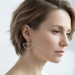 A model wearing handmade sterling silver half-moon threader earrings.