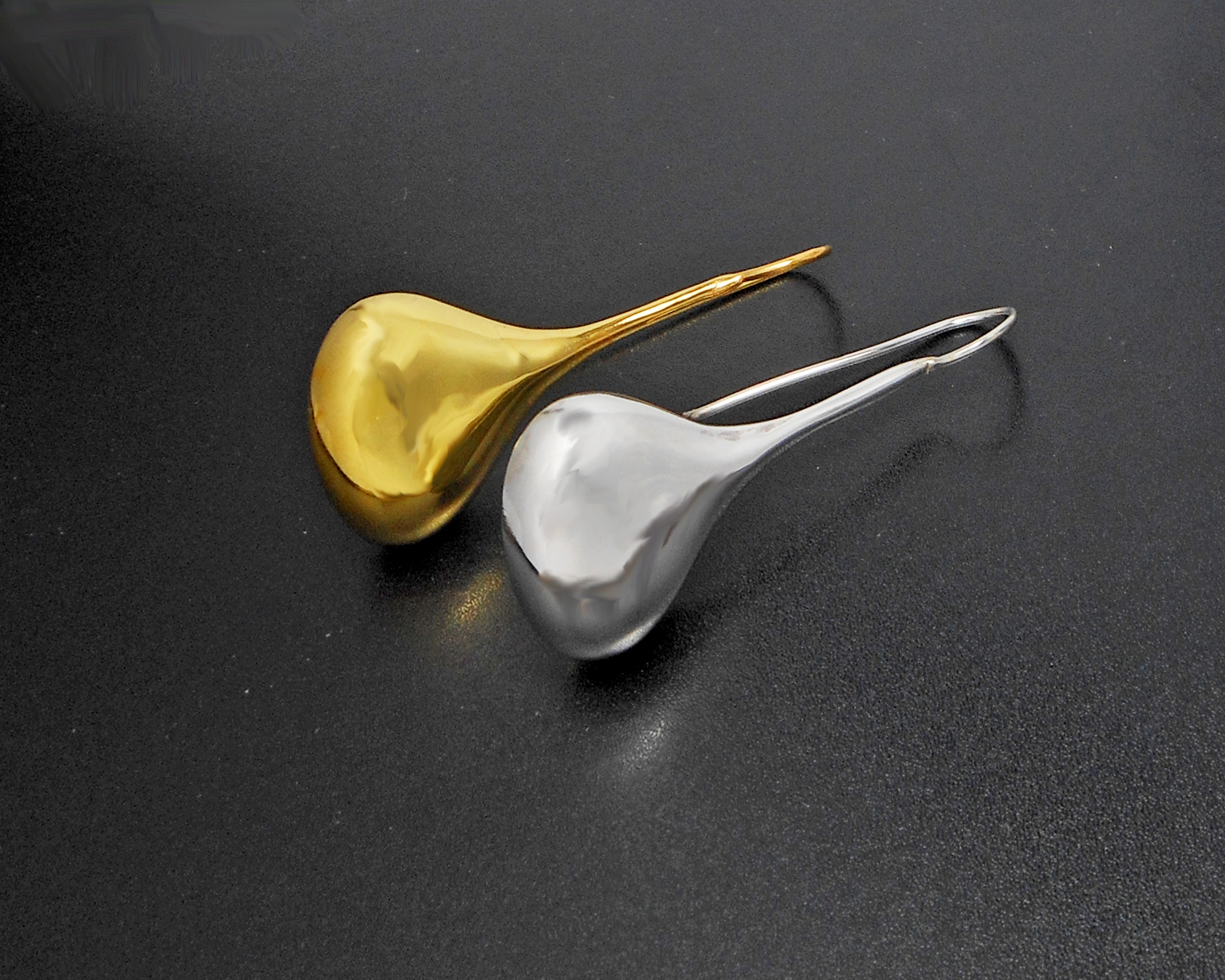 Reflective finish view of long teardrop threader earrings.