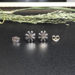Pair of handmade 925 sterling silver daisy flower stud earrings with a smooth, polished finish and textured petals.