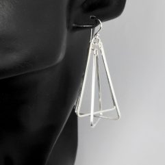 A pair of handcrafted 925 sterling silver multi-spinning triangle pyramid drop earrings displayed on a black mannequin, highlighting their kinetic geometric design.