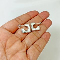 Pair of handmade 925 sterling silver puffy square hoop earrings held in a palm, showing a clean, 3D geometric design.